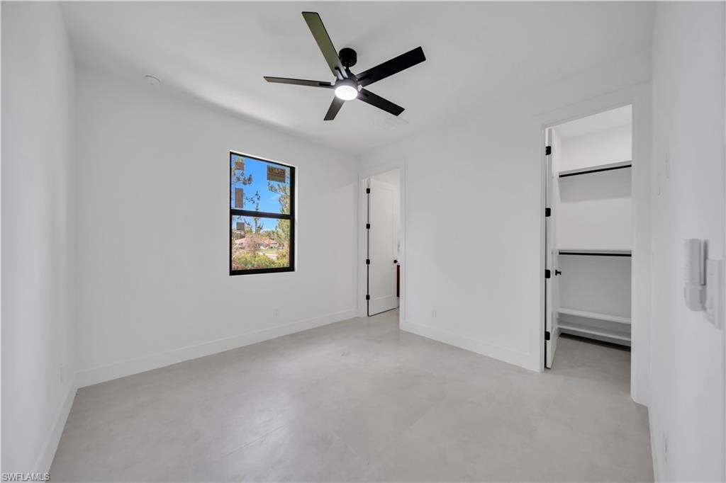 Bright interior space featuring a matte black ceiling fan, recessed lighting, and a window with black trim