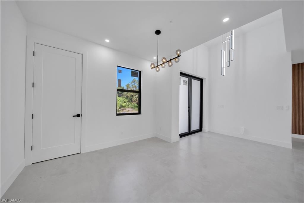 Bright interior space featuring a double-height ceiling, recessed lighting, and light-toned flooring