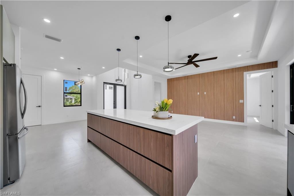 Contemporary kitchen island with a white solid-surface countertop and wood-finish cabinetry