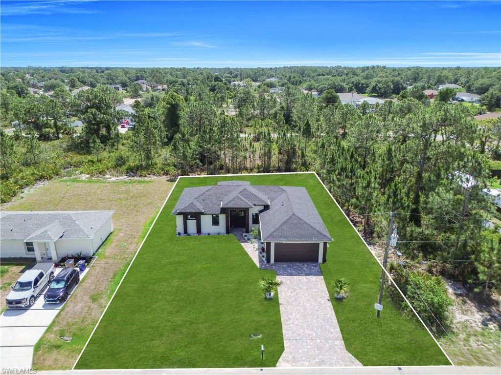 Contemporary single-story residence featuring a dark shingle roof and a paver driveway