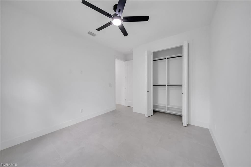Spacious room featuring light gray tile flooring and white baseboards