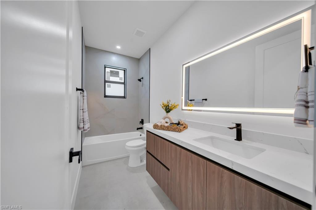 Contemporary bathroom featuring a floating wood-finish vanity with an integrated sink and white countertop