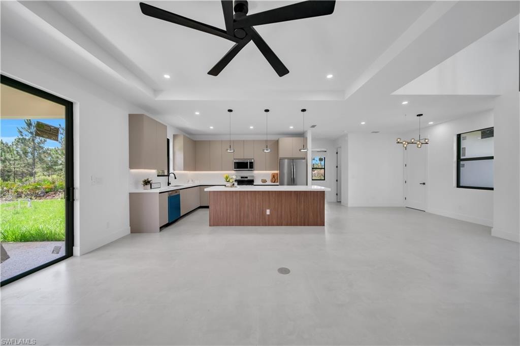 Open-concept living area featuring a modern kitchen with a large island, stainless steel appliances, and contemporary cabinetry