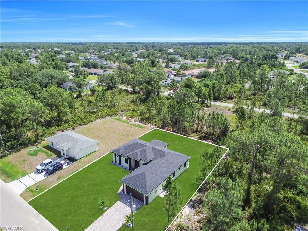 Contemporary single-story residence featuring a dark shingle roof and a spacious, manicured green lawn