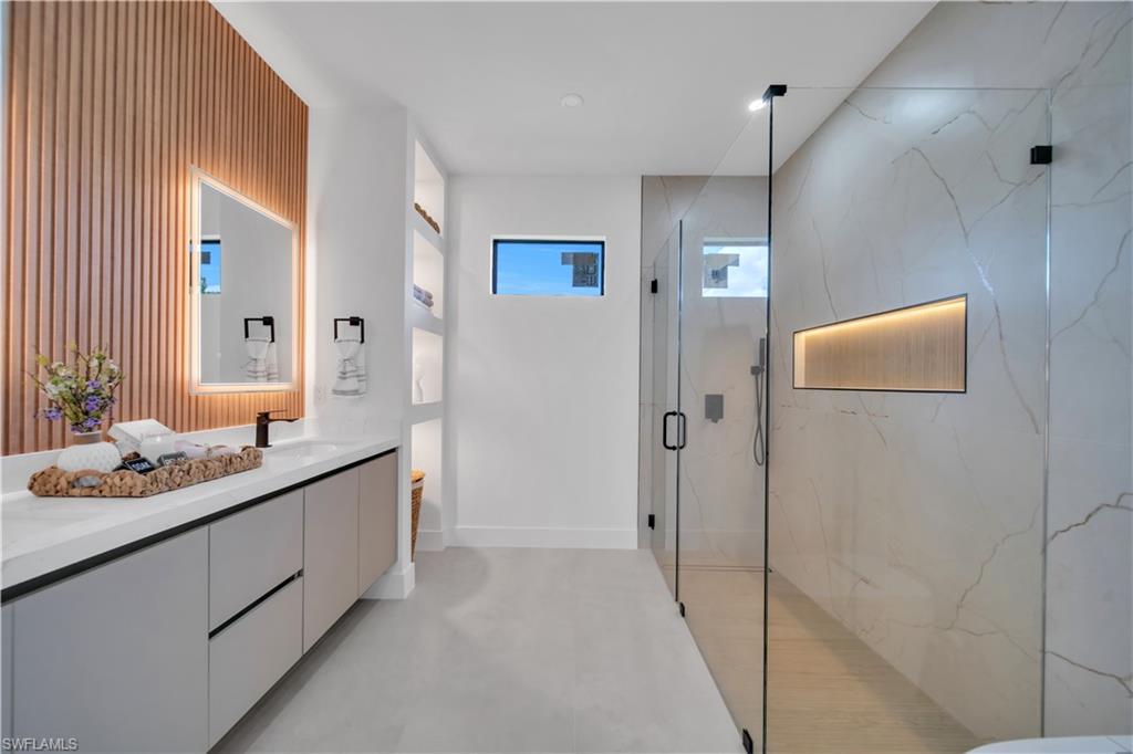 Dual vanity with light gray cabinetry, white countertop, and integrated matte black faucets