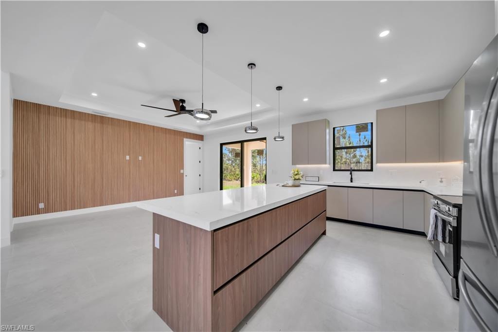 Modern kitchen with an expansive center island, quartz countertops, and sleek flat-panel cabinetry