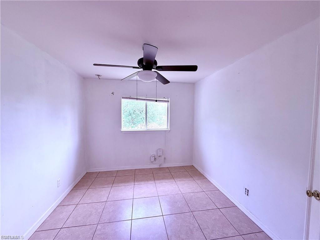 Unfurnished room featuring light tile patterned floors and a ceiling fan