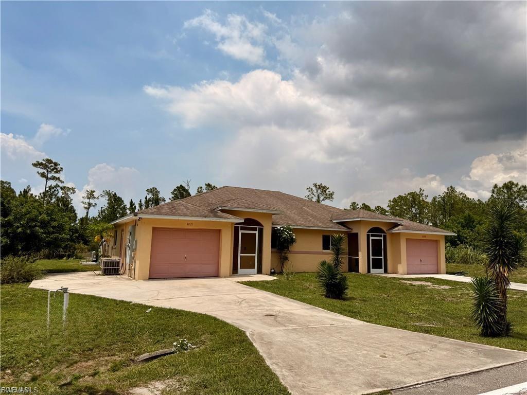 Single story home with a front yard, stucco siding, a garage, driveway, and roof with shingles