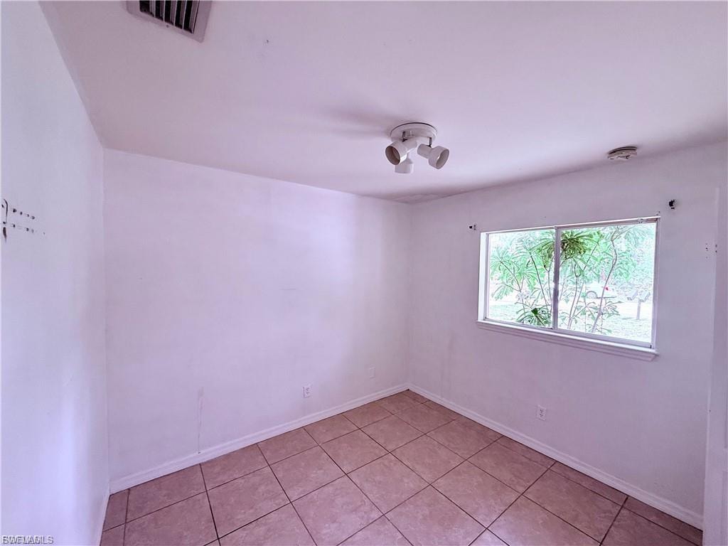 Spare room featuring light tile patterned floors and baseboards