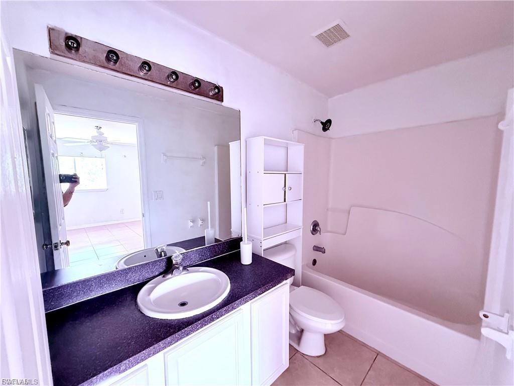 Bathroom featuring vanity, light tile patterned floors, and tub / shower combination