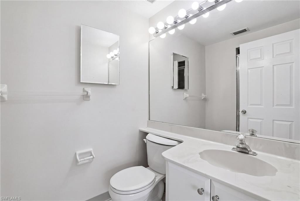 Bathroom vanity with an integrated sink, polished chrome faucet, and a large wall-mounted mirror