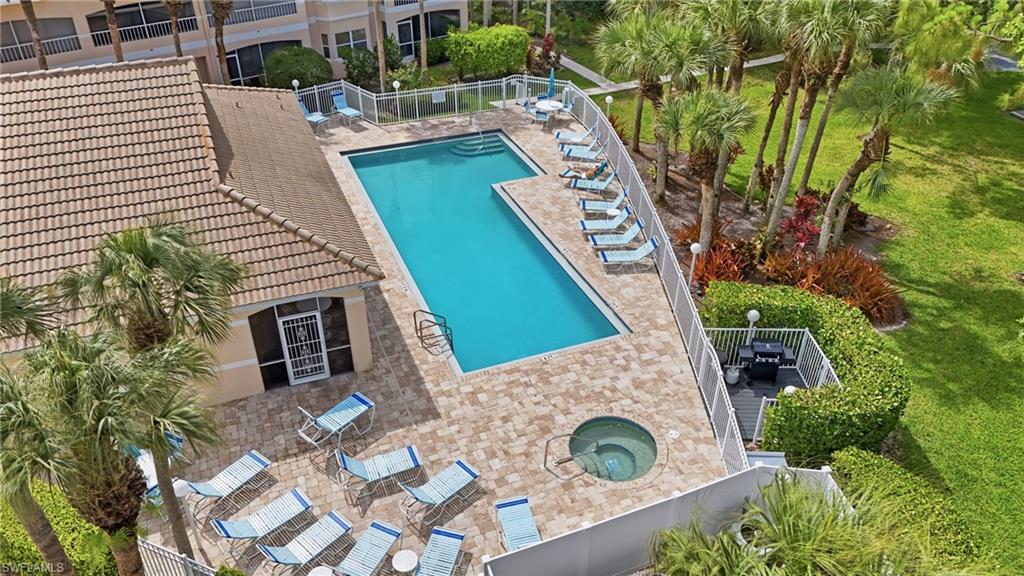 Inviting outdoor amenity space featuring a rectangular swimming pool, integrated spa, and expansive paver deck