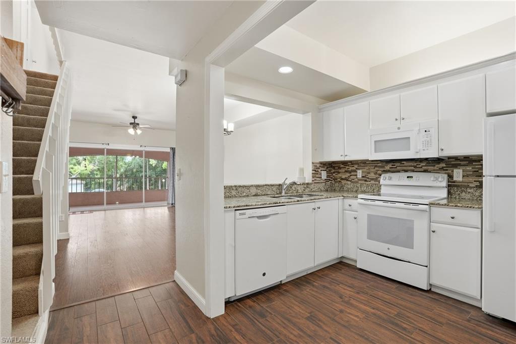 White kitchen featuring granite countertops and a tiled backsplash