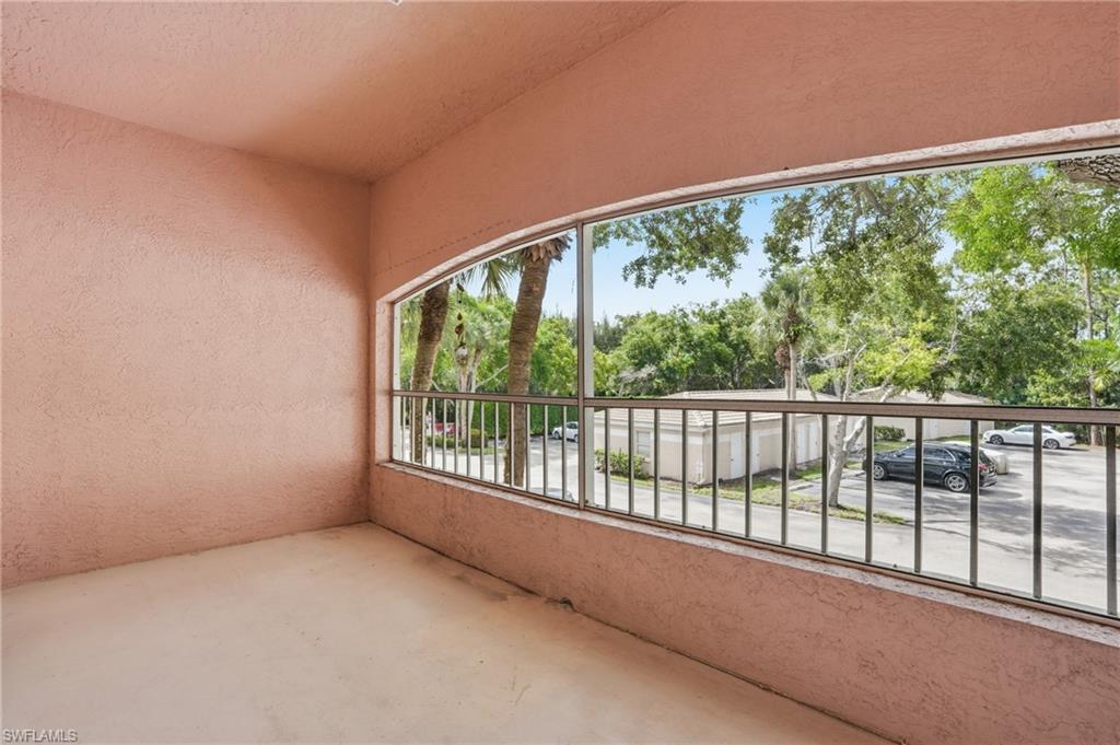 Screened balcony featuring a textured wall finish and a metal railing