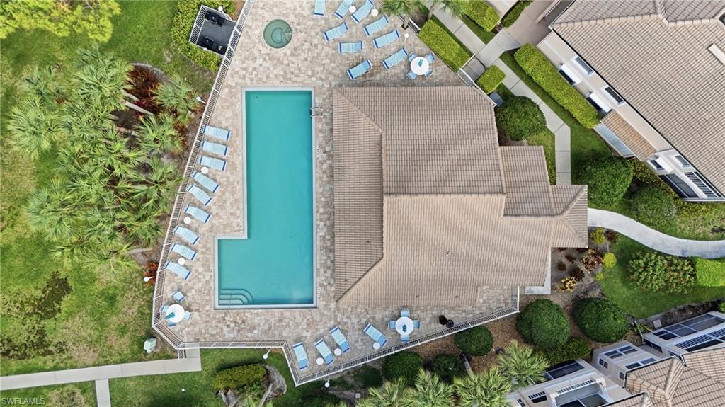Resort-style pool area featuring a rectangular pool with integrated steps, a circular spa, and a paver deck