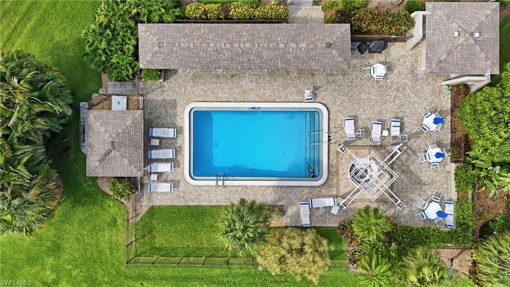 Outdoor swimming pool with integrated steps, surrounded by an expansive paver patio