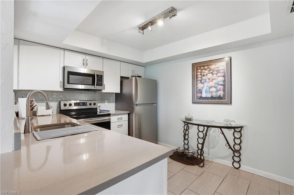 Kitchen featuring light-toned countertops, white cabinetry, and stainless steel appliances