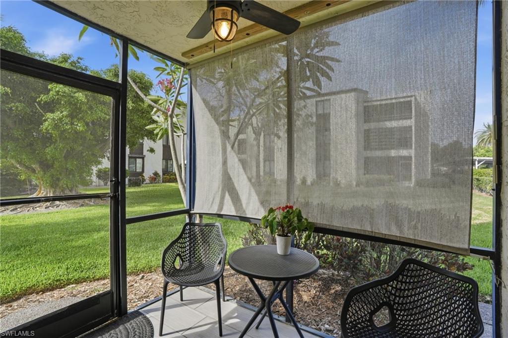 Screened patio featuring a ceiling fan with integrated lighting, durable floor tiling, and retractable privacy screens