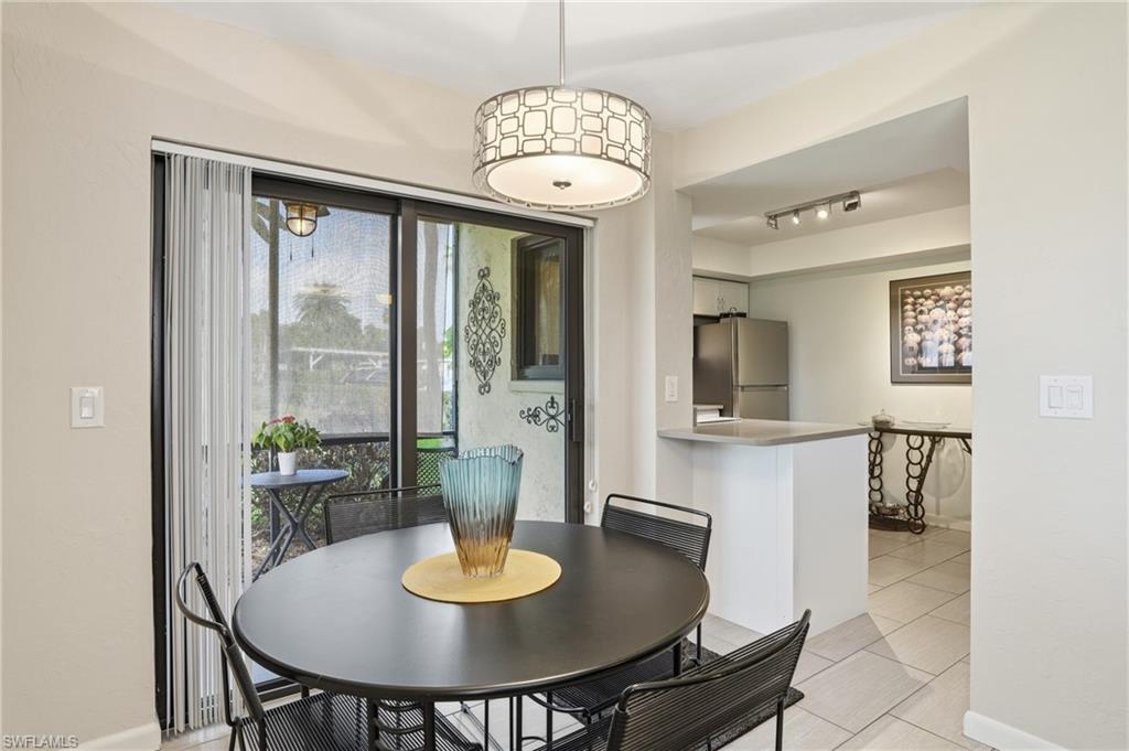 Dining area featuring a contemporary drum chandelier, sliding glass doors to the exterior, and tile flooring