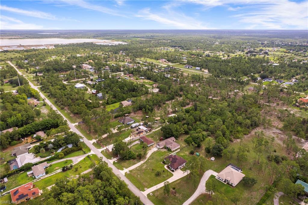 Expansive aerial perspective showcasing a residential area with varied housing styles and extensive natural tree coverage