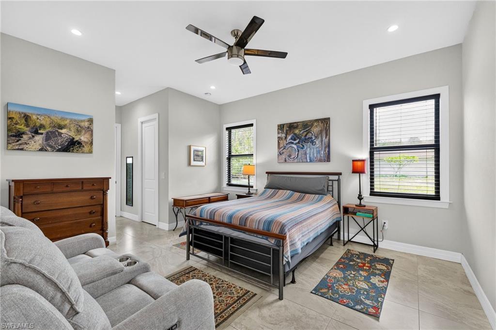 Bright room featuring light-toned tile flooring, recessed lighting, and a ceiling fan