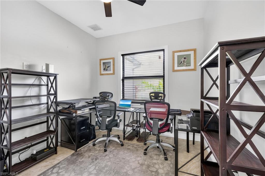 Dedicated workspace featuring a window with horizontal blinds, a ceiling fan, and light-toned flooring