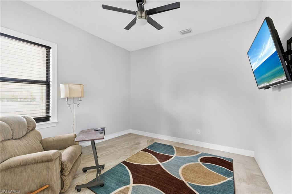Room featuring light-toned walls, tile flooring, and a ceiling fan with integrated lighting