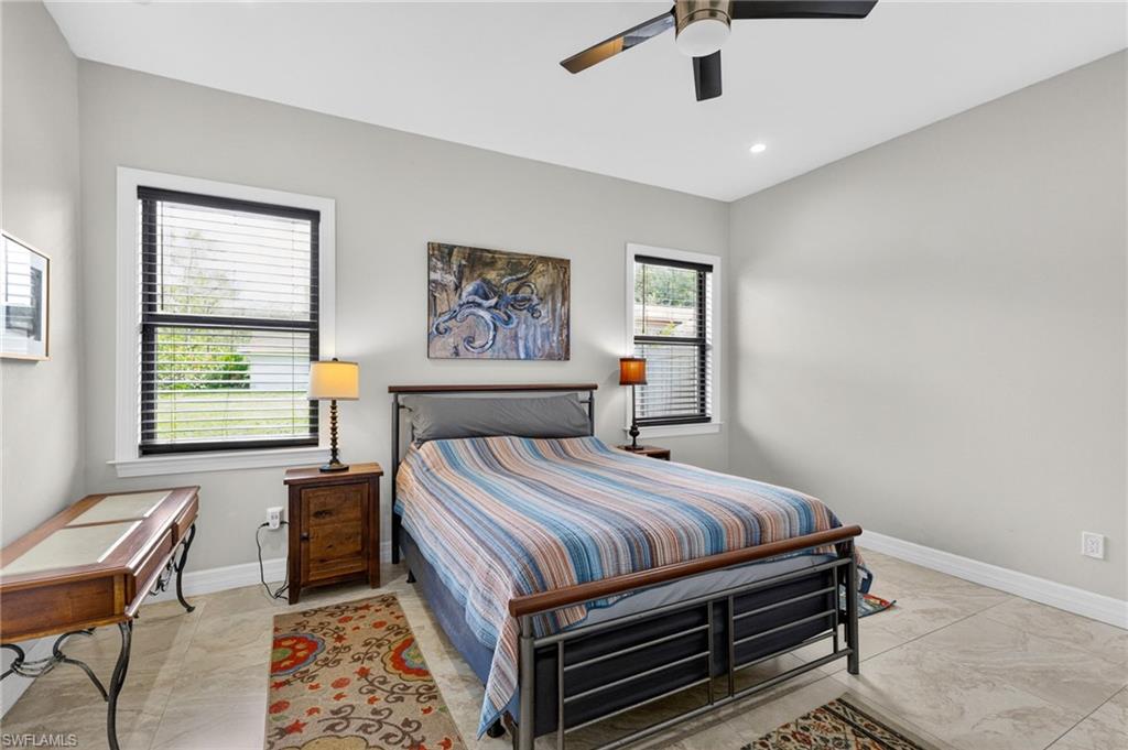 Bedroom featuring light gray walls, two windows with blinds, a ceiling fan, and recessed lighting