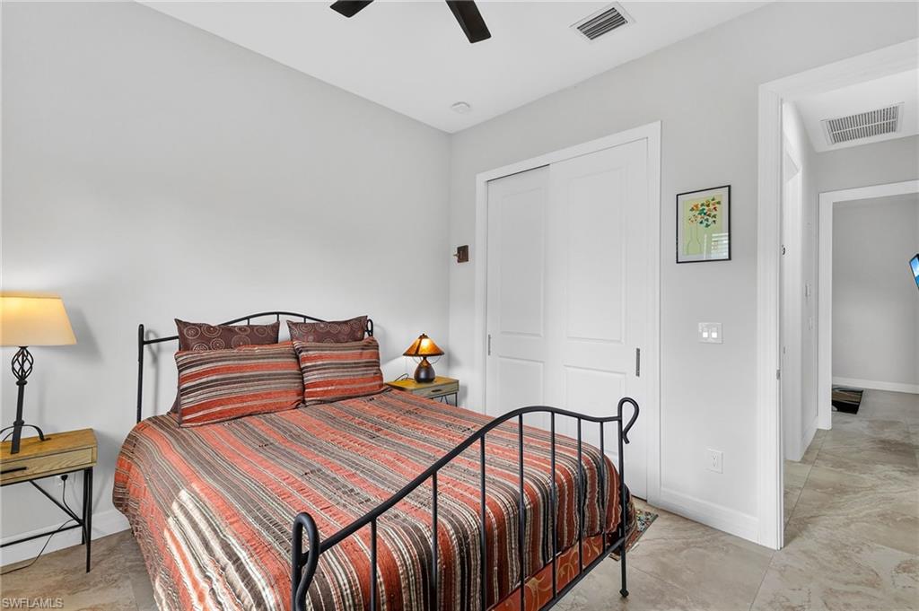 Bedroom with light neutral wall paint, a ceiling fan, and tiled flooring