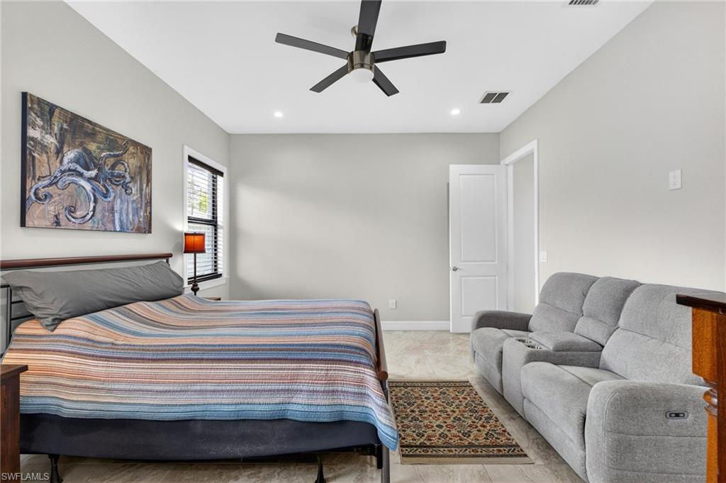 Spacious room featuring light-toned walls, a modern ceiling fan, recessed lighting, a window with horizontal blinds, and tile flooring