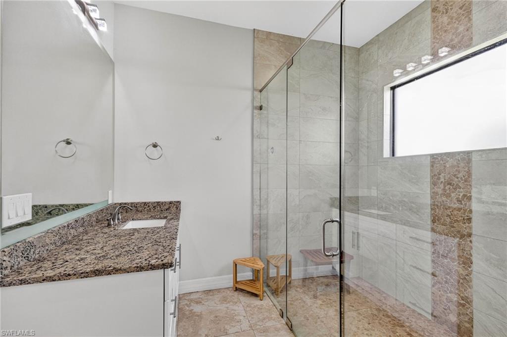 Walk-in shower with clear glass enclosure and built-in bench
