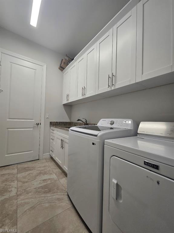 Laundry area featuring extensive white upper cabinetry and a coordinating white lower cabinet
