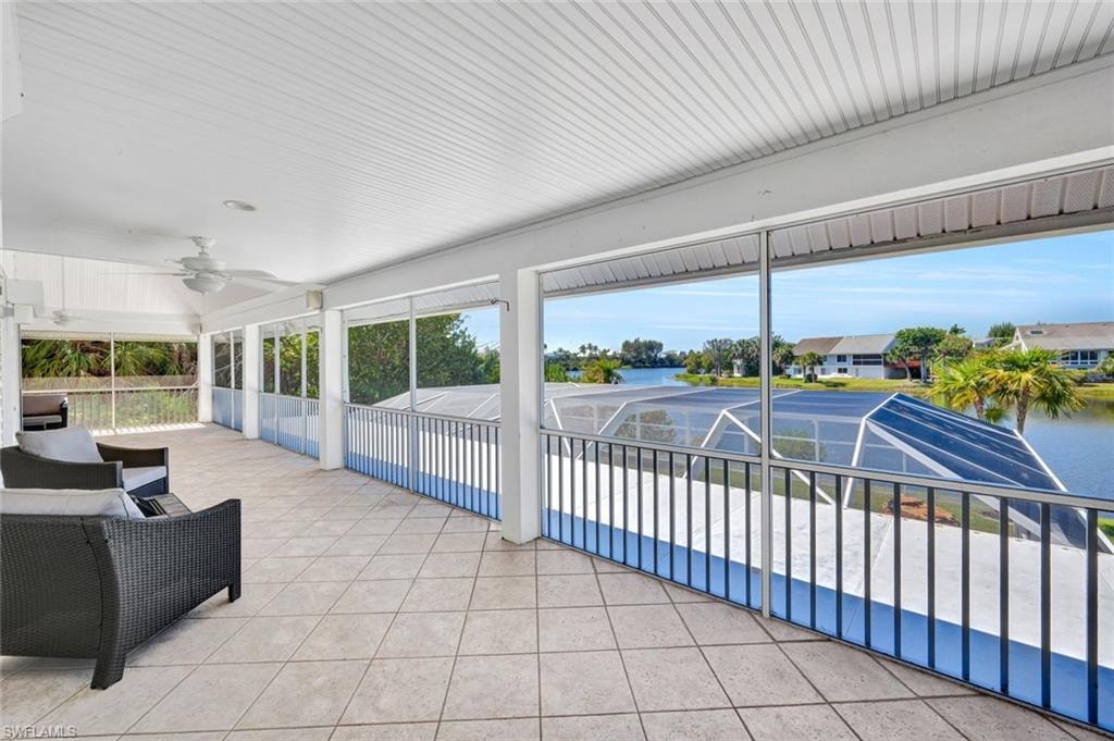 Expansive screened balcony featuring diagonal tile flooring, a slatted ceiling, and an integrated ceiling fan