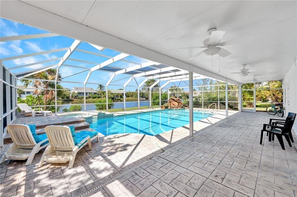 Screened lanai featuring a swimming pool, integrated spa, and expansive stamped concrete patio
