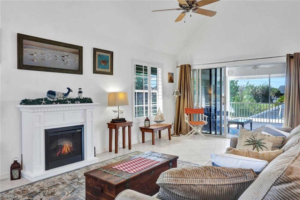 Living area featuring a vaulted ceiling, ceiling fan, and large format tile flooring