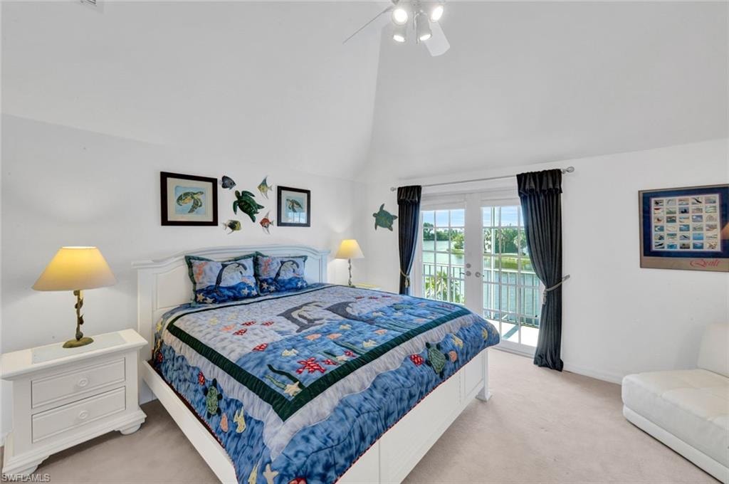 Bedroom featuring vaulted ceilings, plush carpet flooring, a ceiling fan, and French doors opening to a balcony with white railings