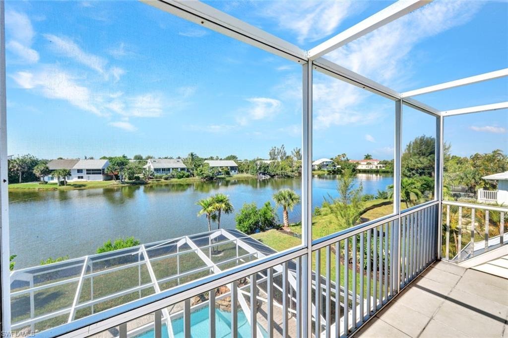 Screened balcony with open water views, featuring a tiled floor and white railing