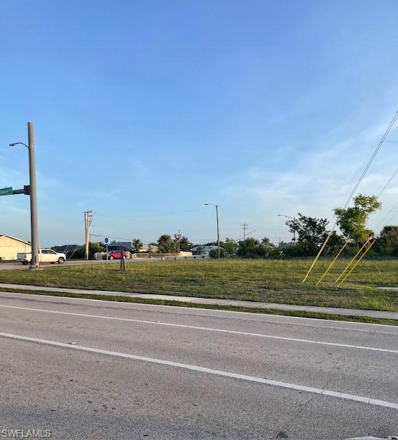 Expansive lot featuring green space, roadside access, and clear skies