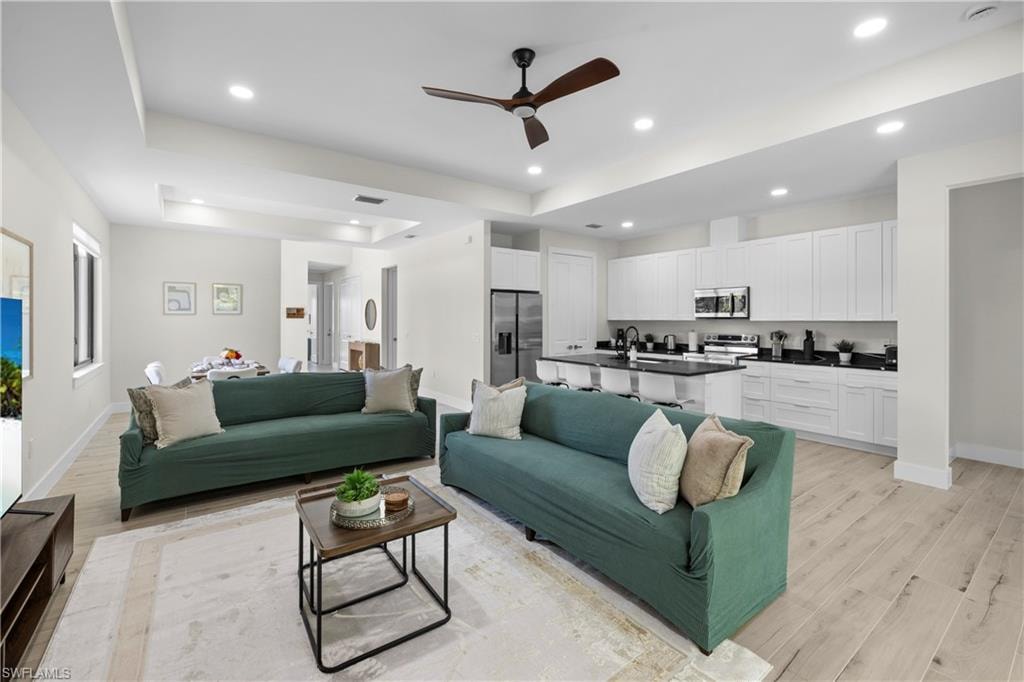 Open-concept living space featuring wood-finish flooring, recessed lighting, and a modern ceiling fan