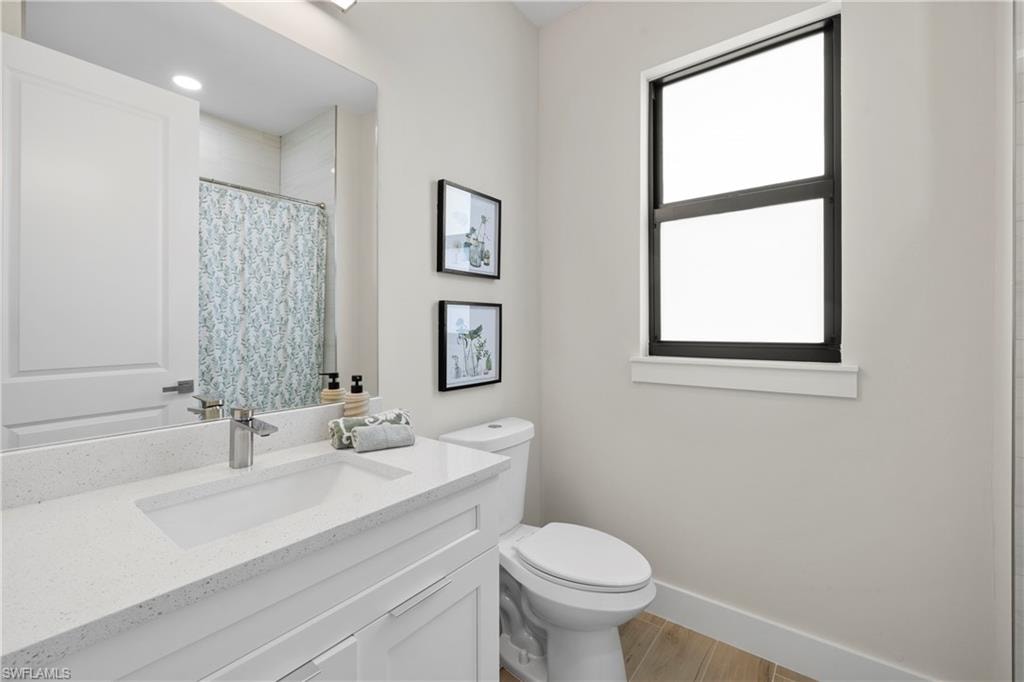 Bathroom featuring a white vanity with an integrated rectangular sink, speckled countertop, and brushed nickel faucet