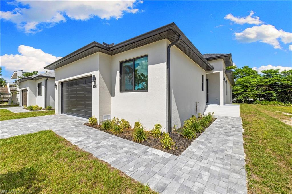 Contemporary exterior featuring a smooth stucco finish and a dark-toned garage door