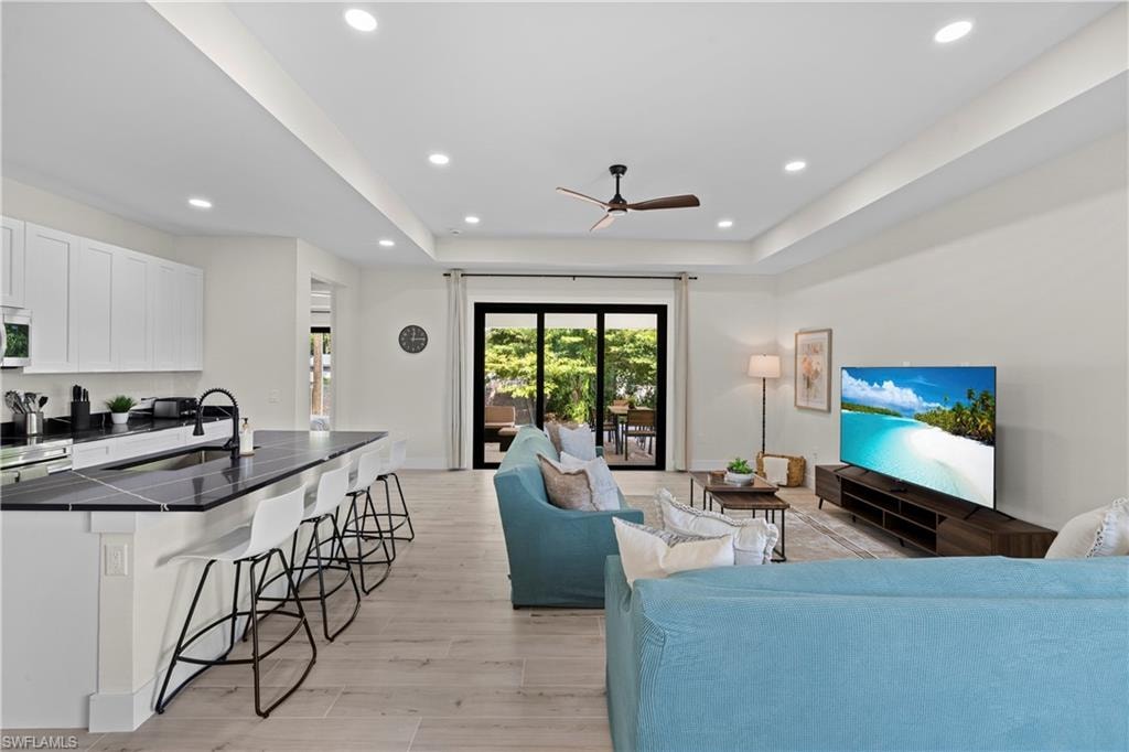 Open-concept living space featuring wood-finish flooring and recessed lighting