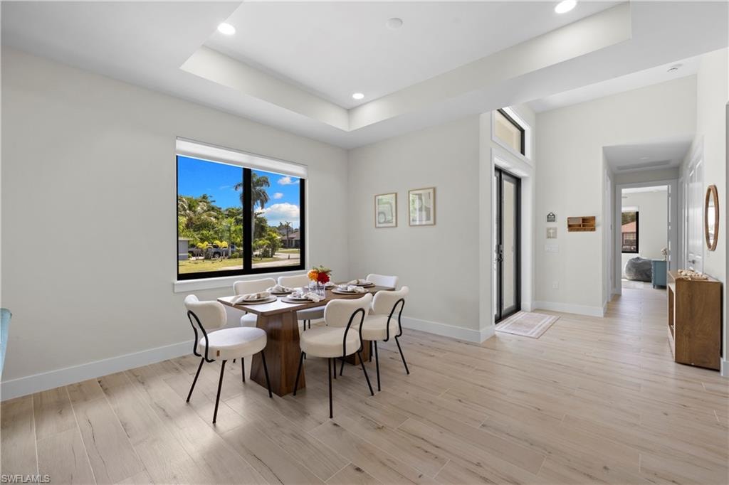 Open concept dining area featuring wood-finish flooring, recessed lighting, and a large window