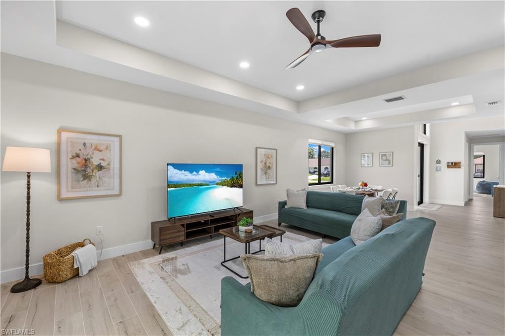 Open-concept living space featuring light wood-finish flooring, recessed lighting, and a contemporary ceiling fan