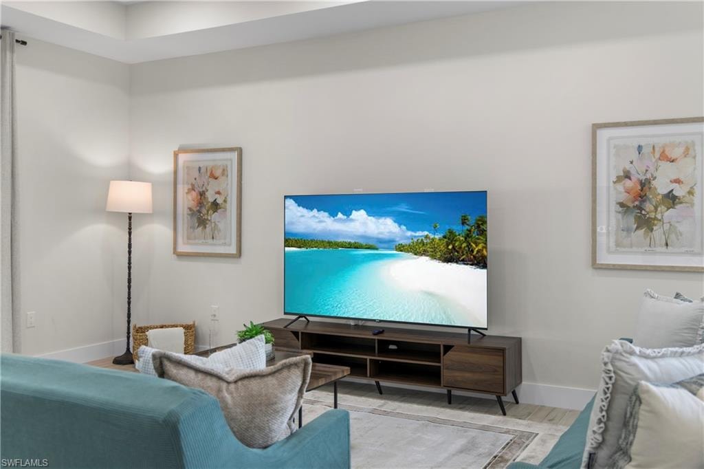 Living area featuring light-toned walls and wood-finish flooring