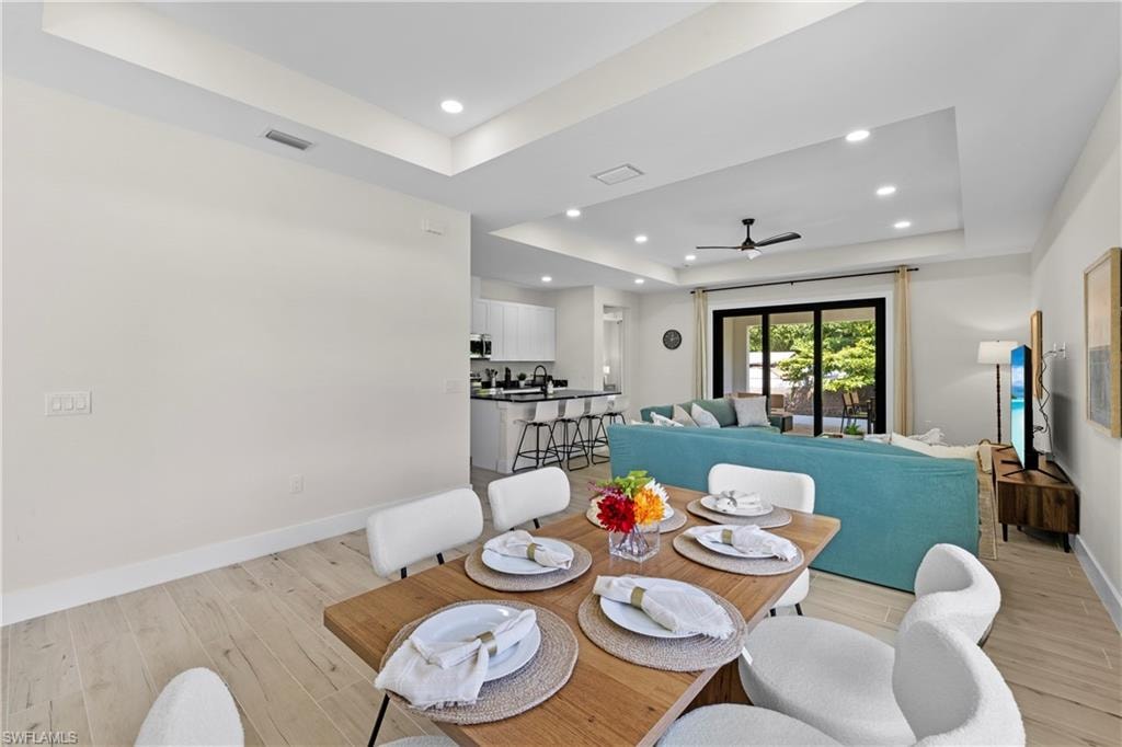 Spacious interior featuring a light wood-finish flooring, recessed lighting, and tray ceilings