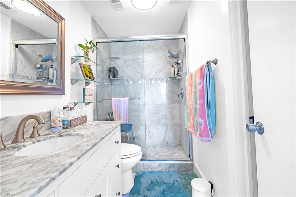 Integrated vanity with an undermount sink, a marble-patterned countertop, and brushed nickel fixtures