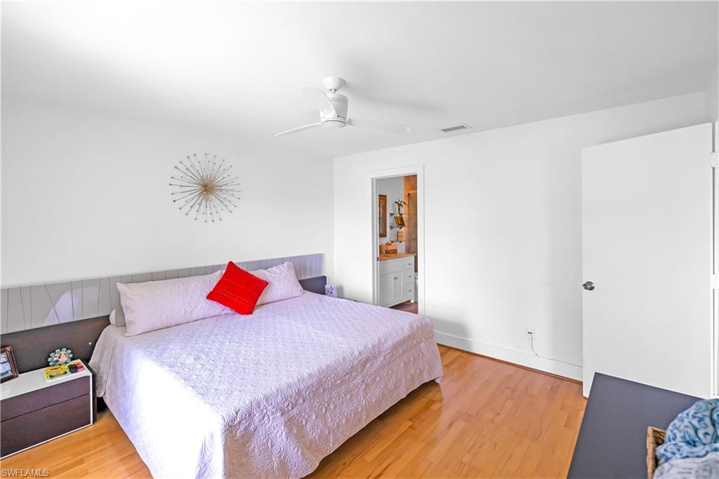 Bedroom featuring wood-finish flooring, a ceiling fan, and white walls