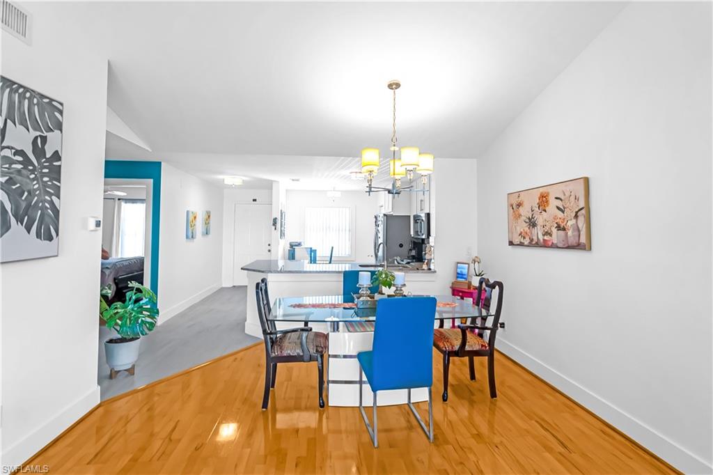 Open concept dining area featuring wood-finish flooring and a contemporary chandelier