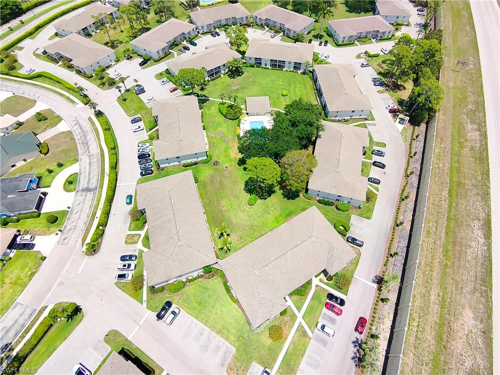 Aerial perspective of a multi-building residential complex featuring a central courtyard with a swimming pool